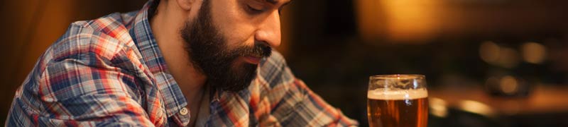 man drinks alone at bar